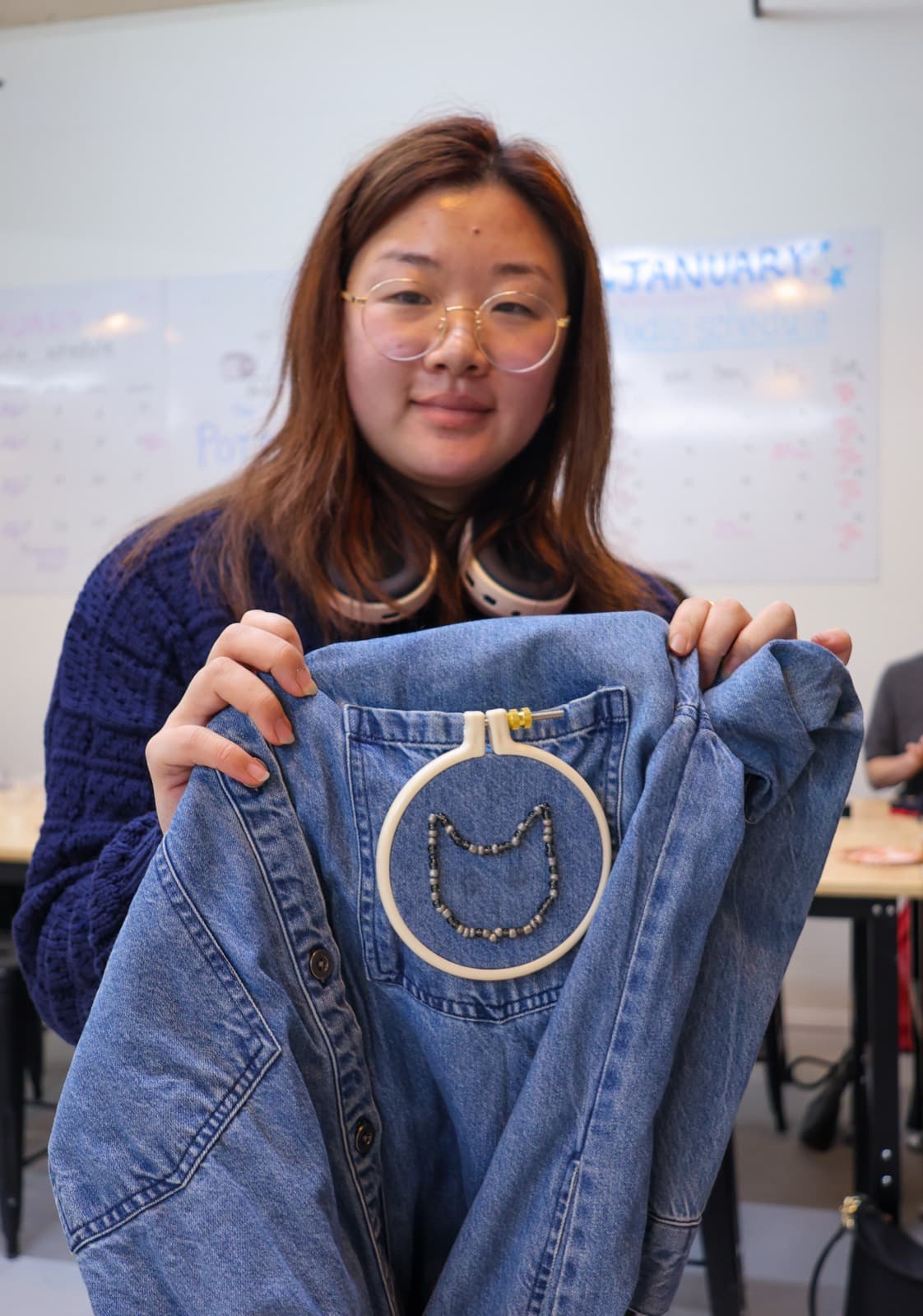 Student holding finished beaded embroidery piece