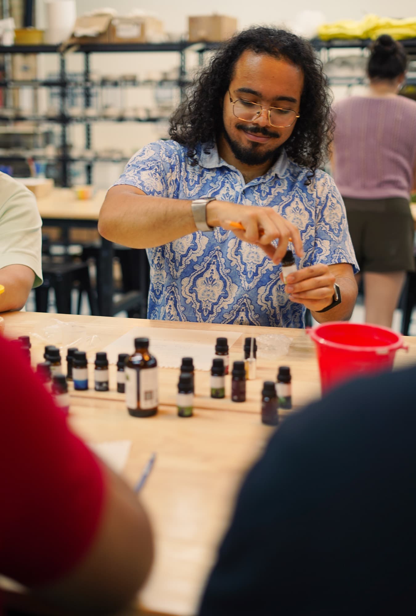 Guest measuring fragrance notes with a pipette at the blending bench