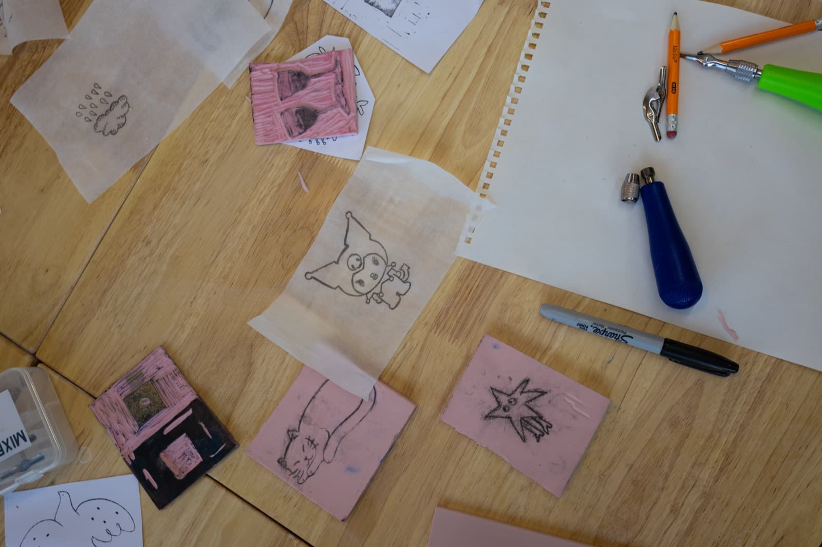Hands carving a linoleum stamp block at Mixed Mediums