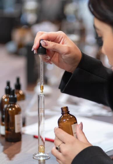 Pipette dropping fragrance accord into a blending vial